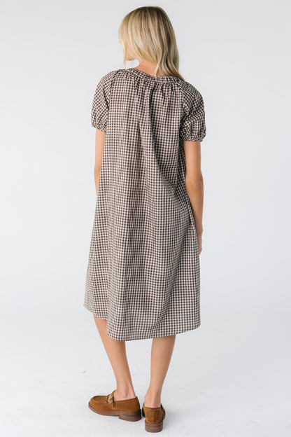 Back view of a woman wearing a brown gingham midi dress