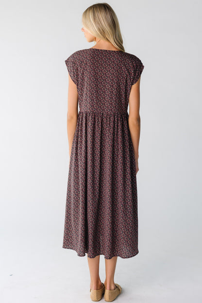 Back view of a woman wearing a black and pink floral midi dress