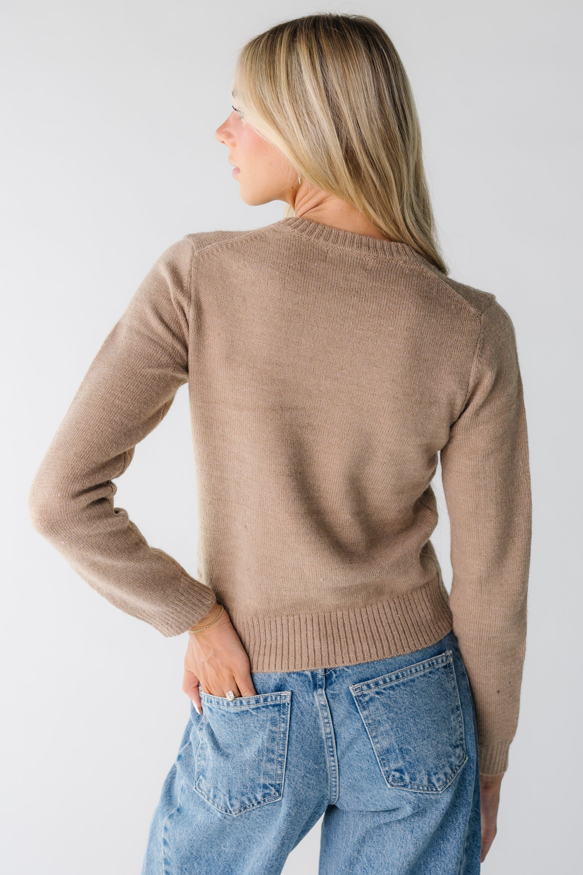 Back view of a woman wearing a long sleeve sweater in mocha