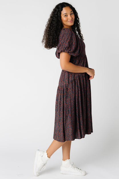 Side view of black floral print dress with short puff sleeves