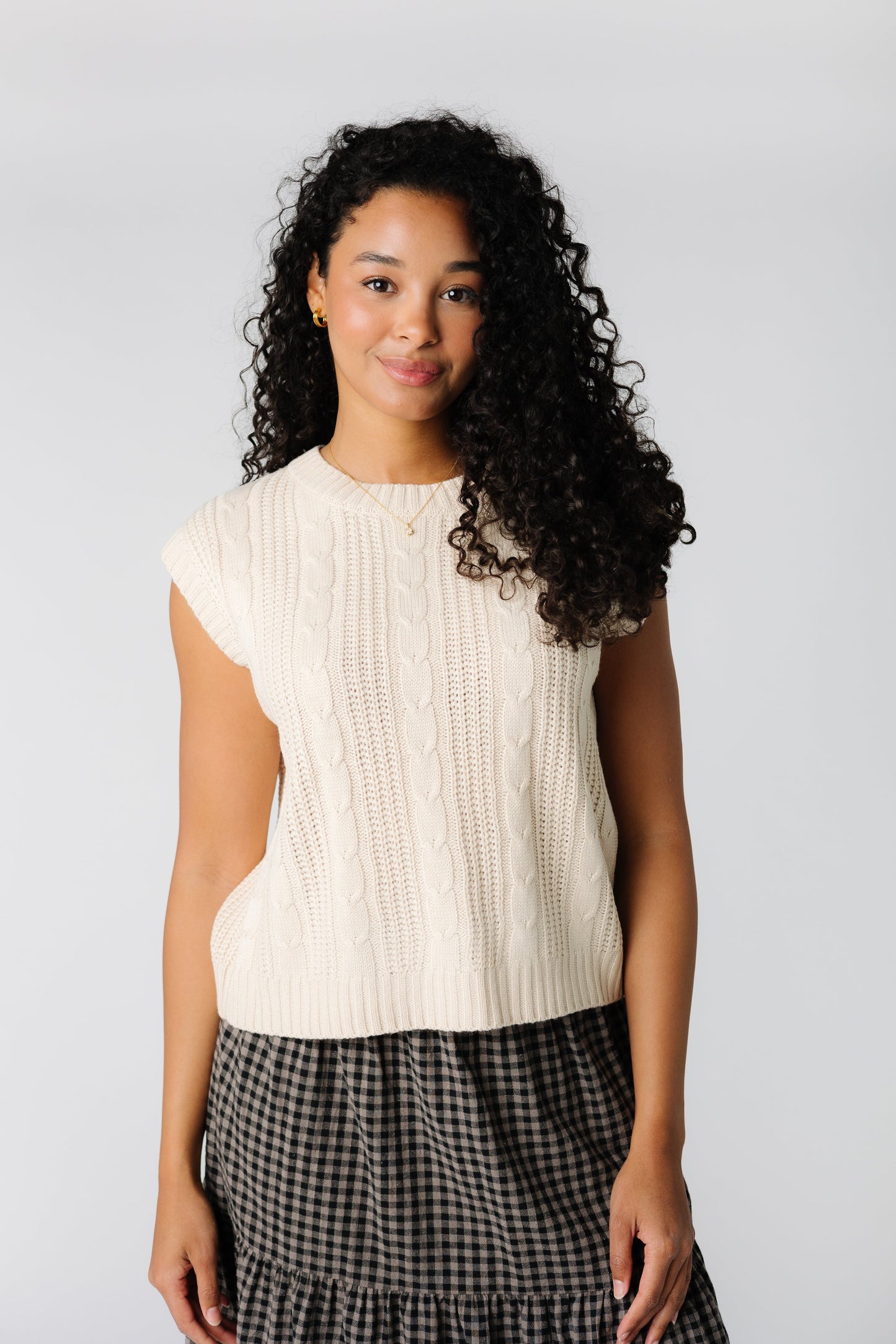 Sleeveless sweater vest with cables and textured stripes