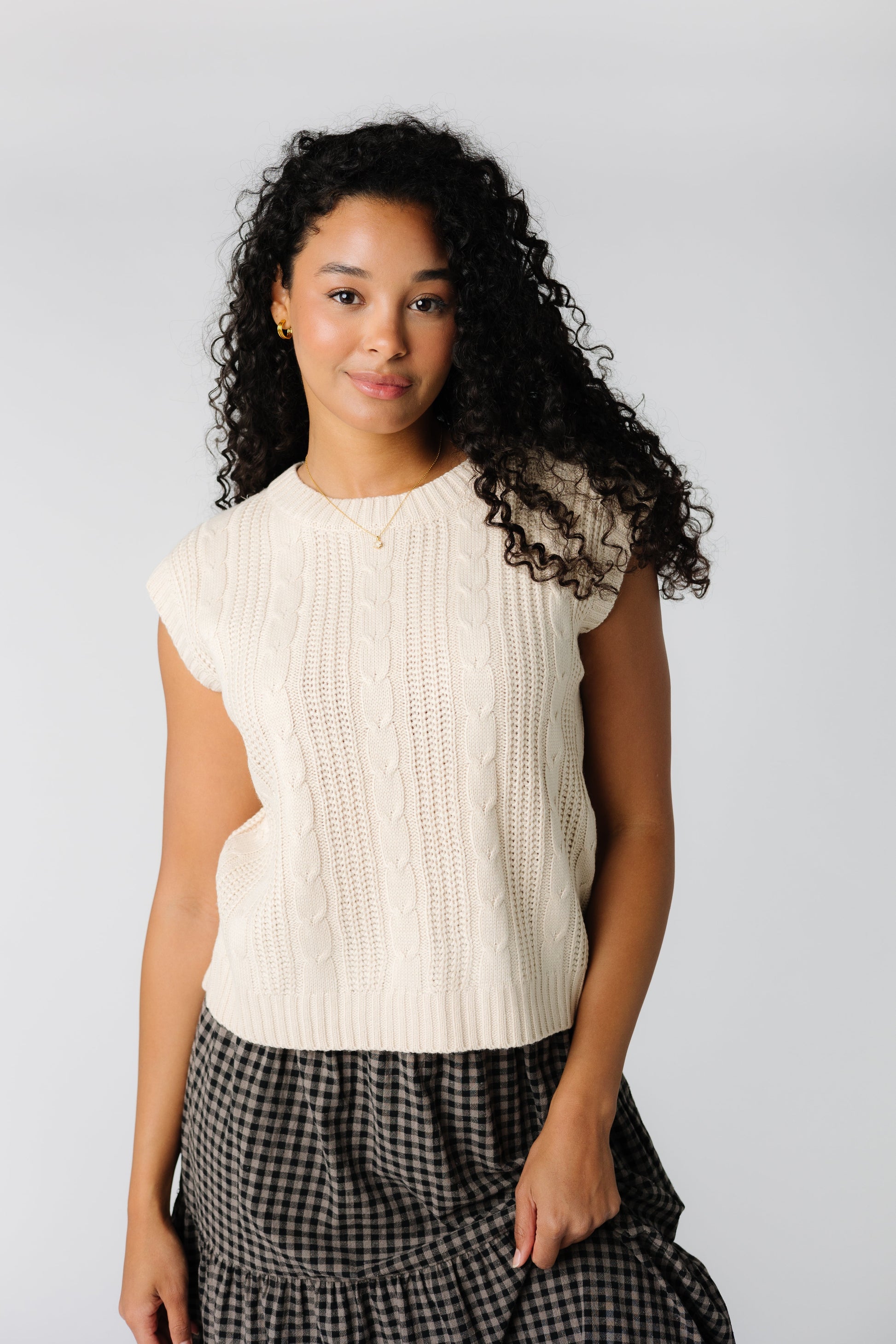 Soft off white sweater vest with wide ribbing and cable details