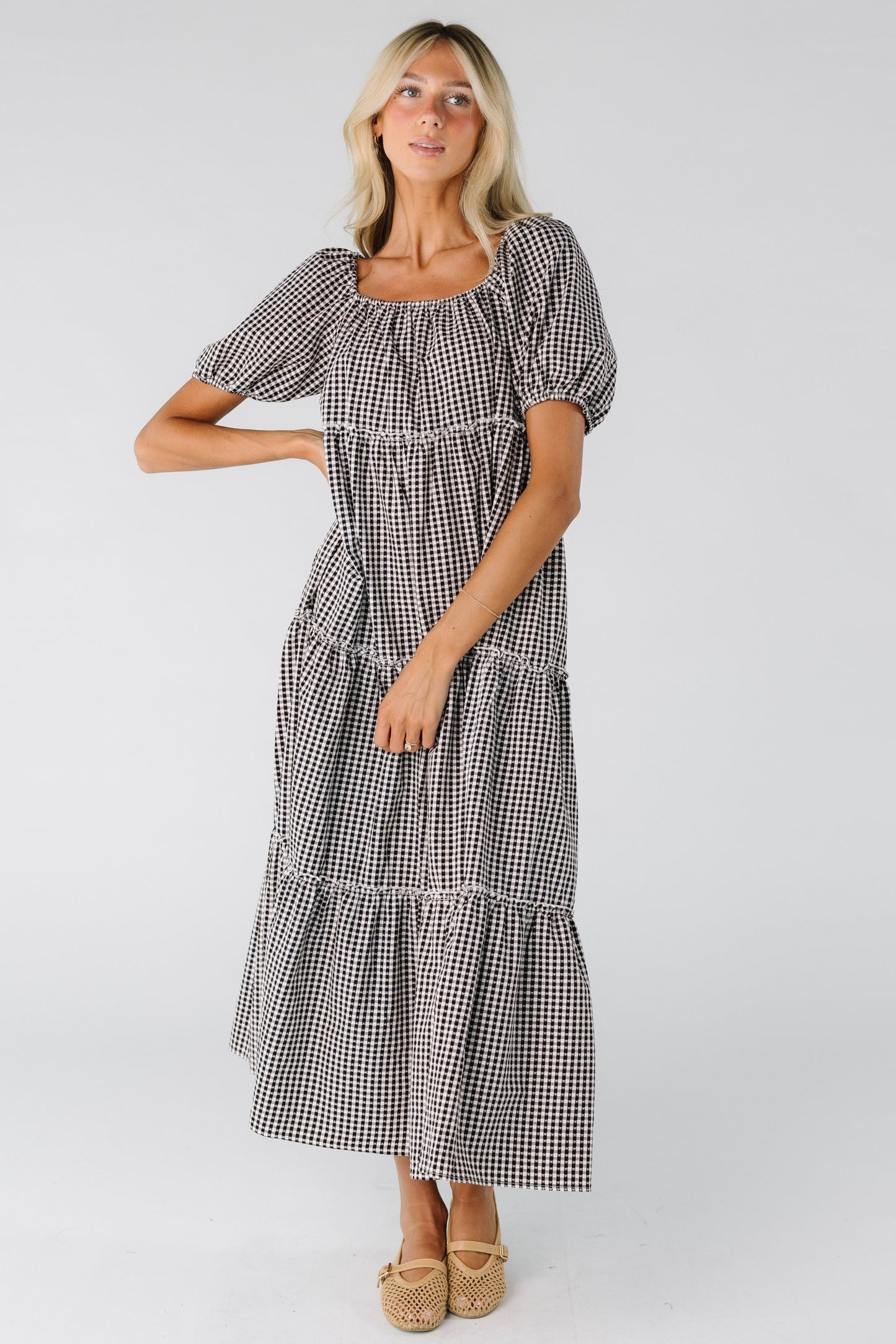 Woman wearing a black and white gingham tiered dress
