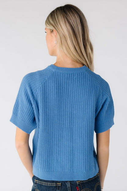 Back view of woman wearing a blue short sleeve sweater
