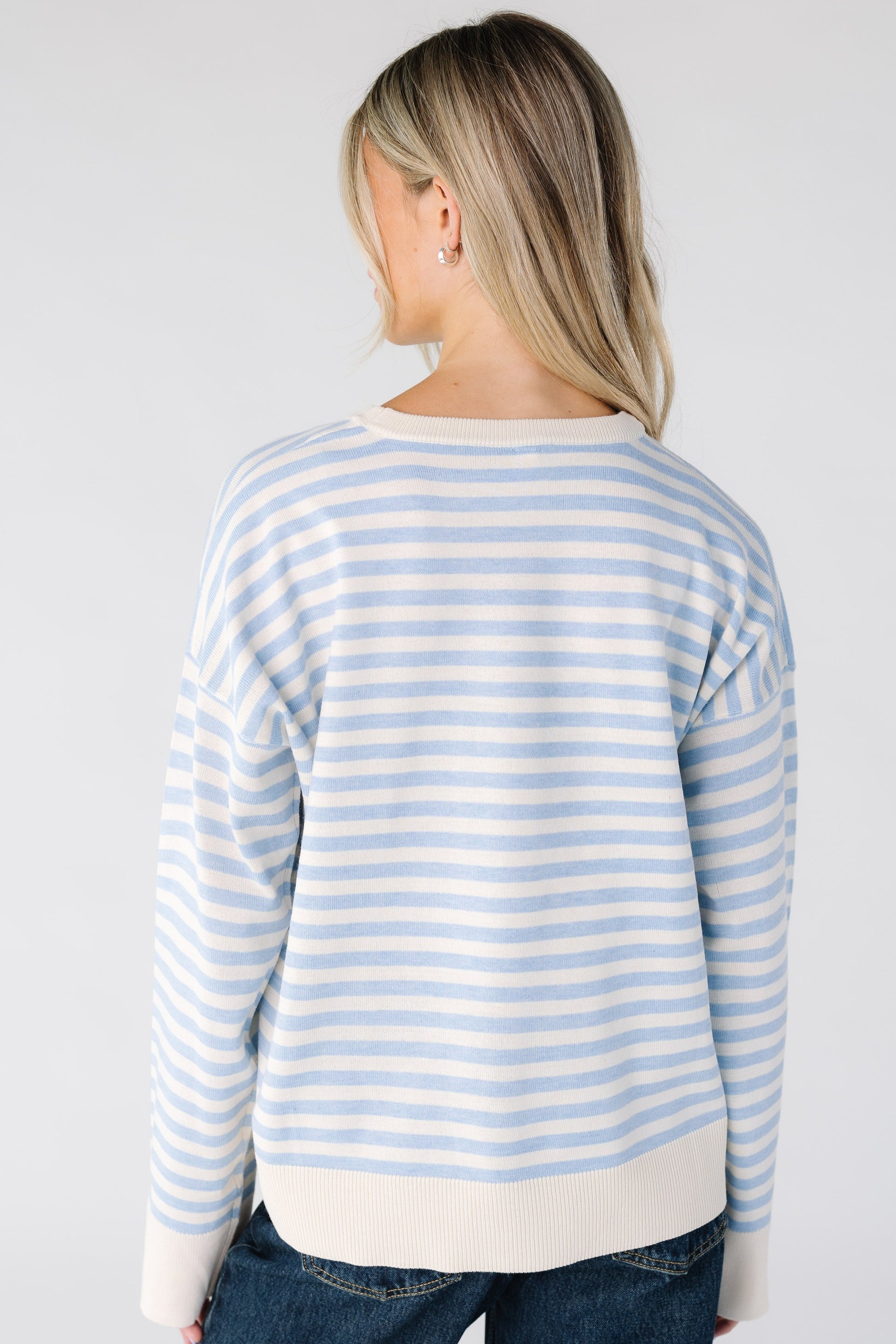 Back view of a woman wearing a light blue and stripe top