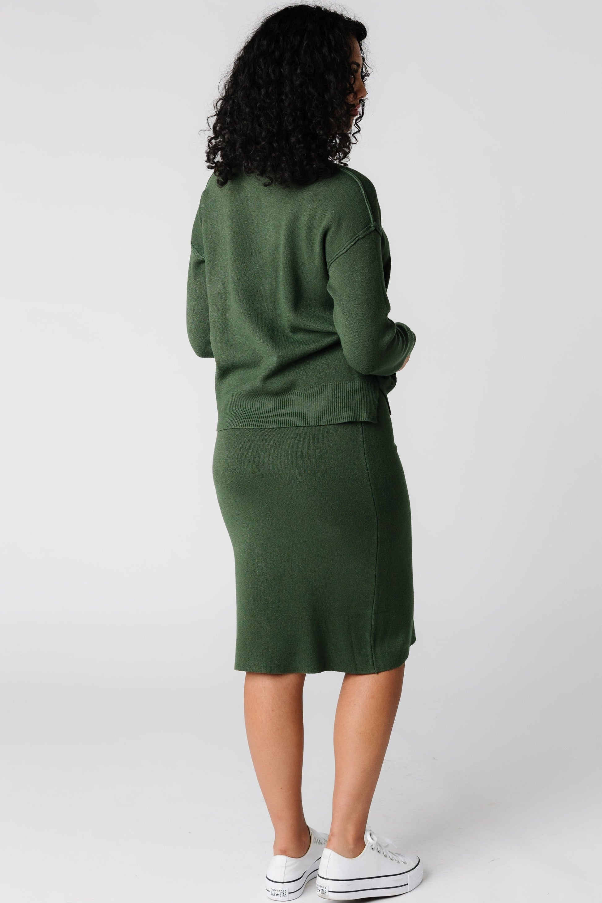 Back view of dark green long sleeve sweater and skirt set