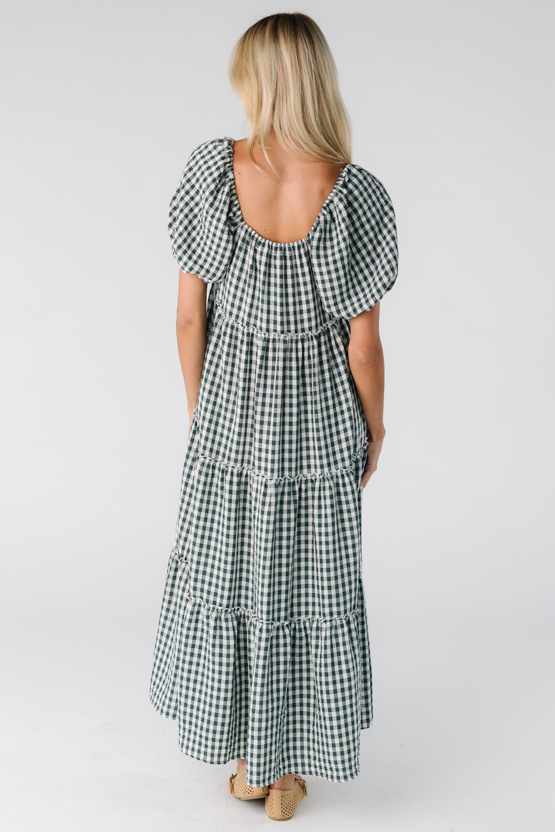 Back view of a woman wearing a loose fitting gingham dress