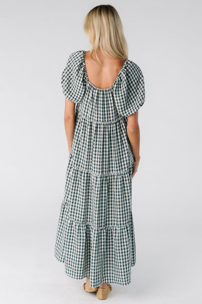 Back view of a woman wearing a loose fitting gingham dress