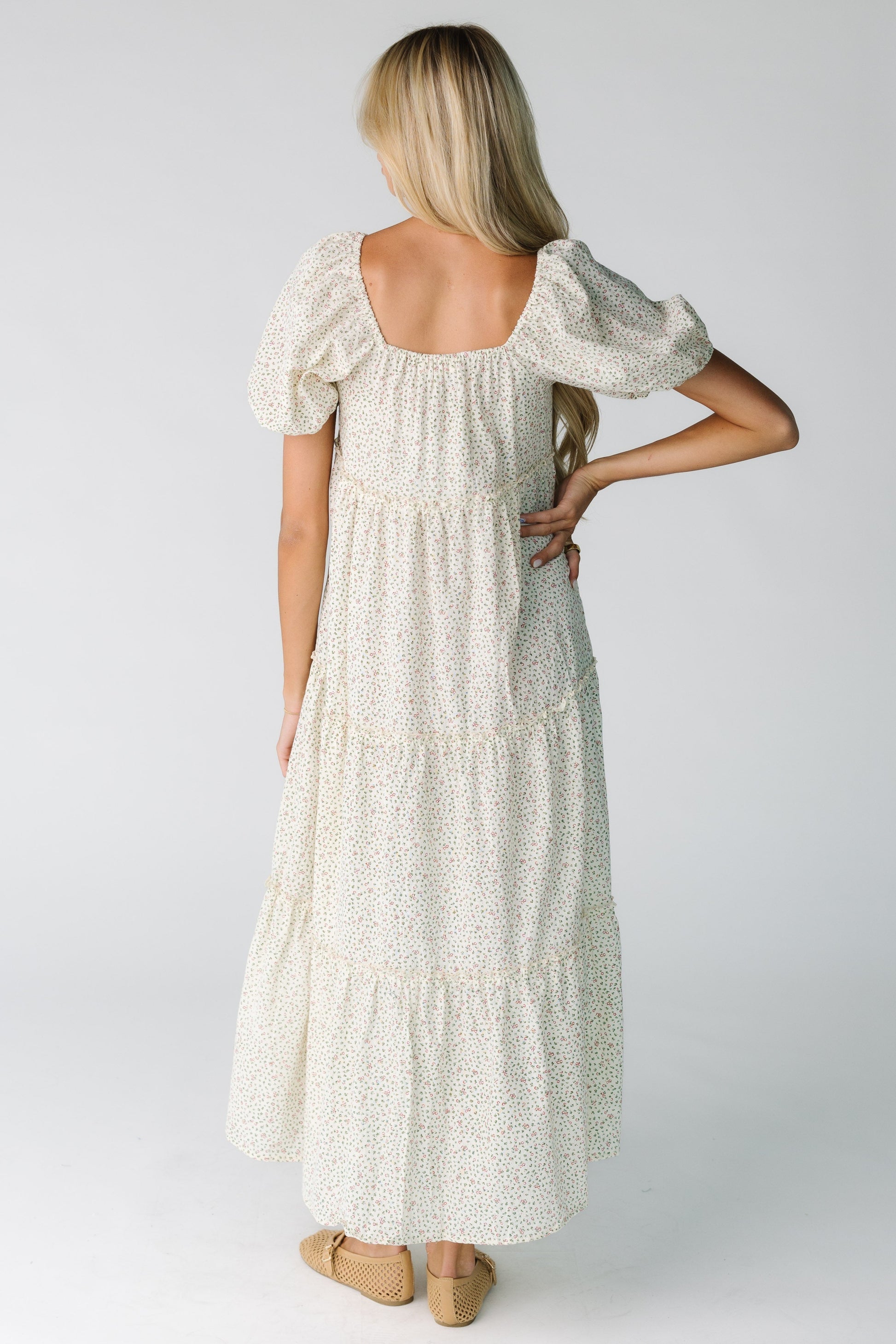 Back view of a woman wearing a cream floral print dress