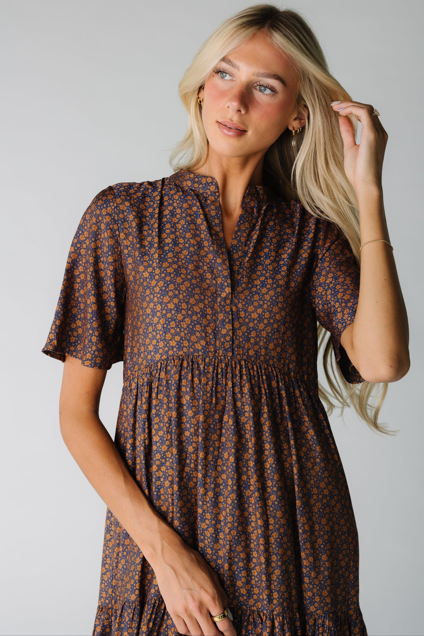 Close view of a woman wearing a modest navy print dress with short sleeves and  V-neckline