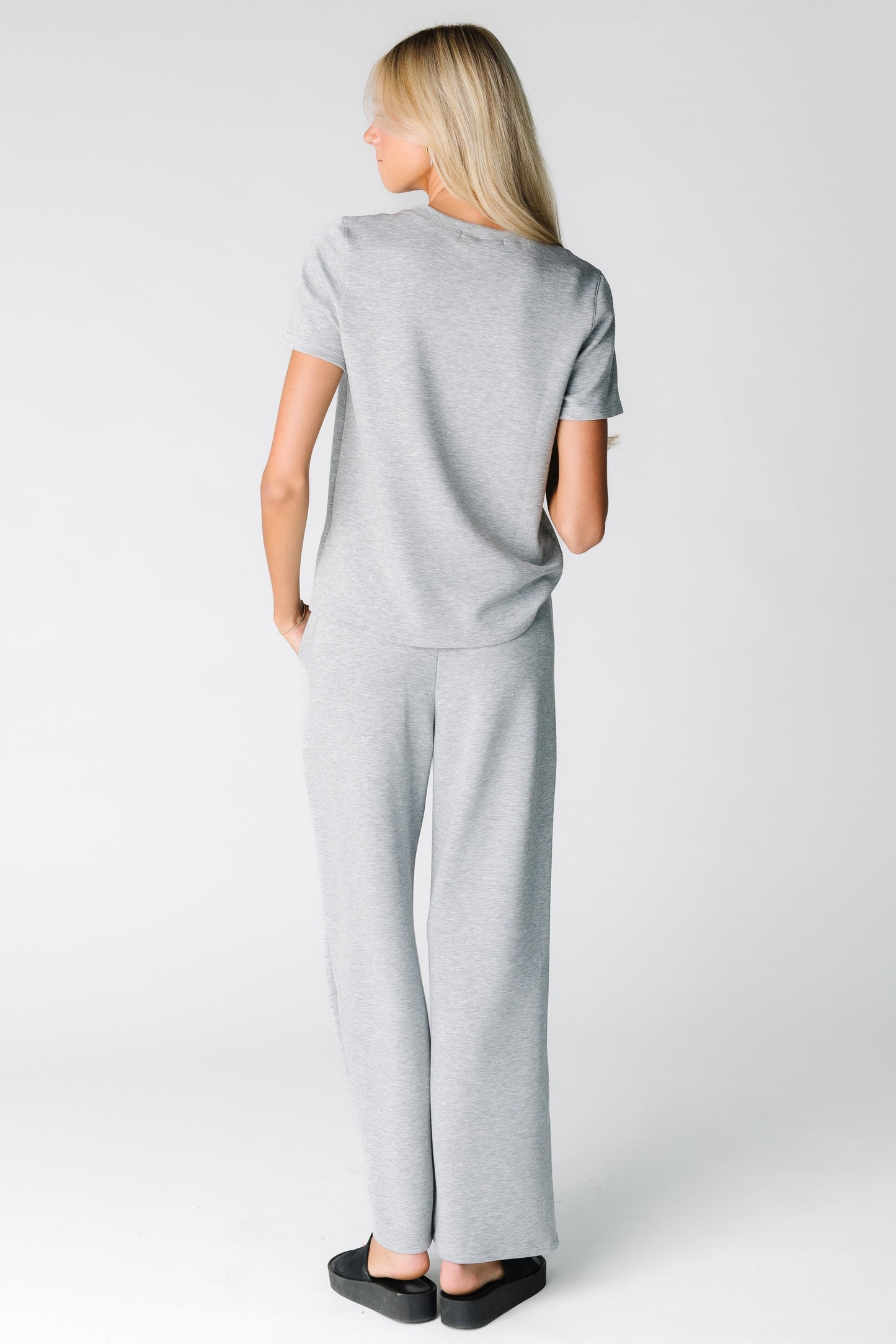 Back view of a woman wearing a light grey lounge set in 2 pieces with short sleeves