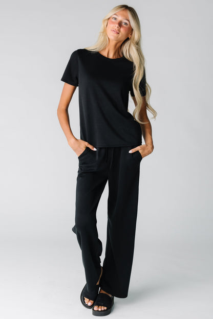 Woman wearing a soft black lounge set with side pockets in the pants