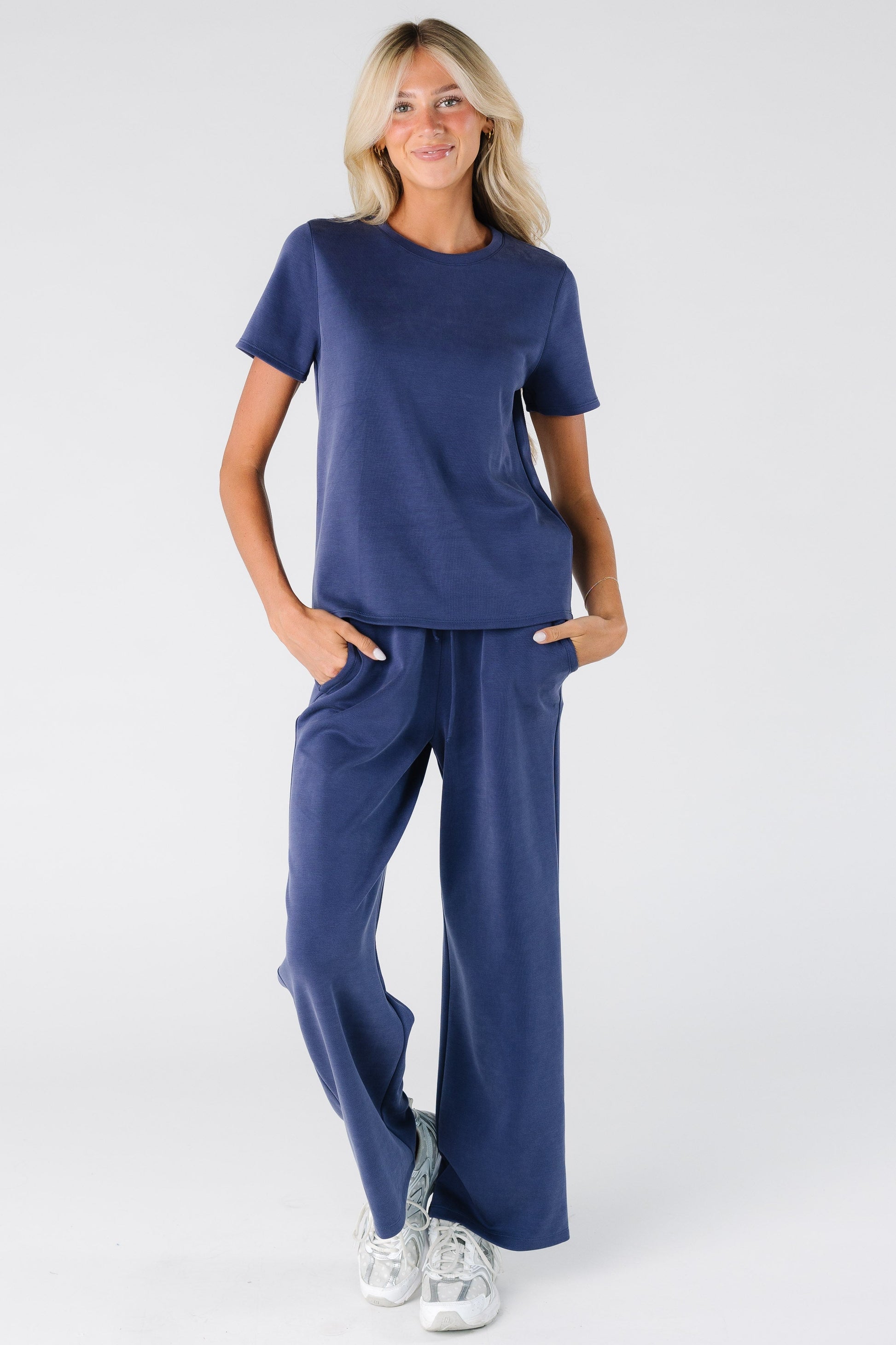 Woman wearing a modest lounge 2 piece set with short sleeves and full length pants in indigo blue