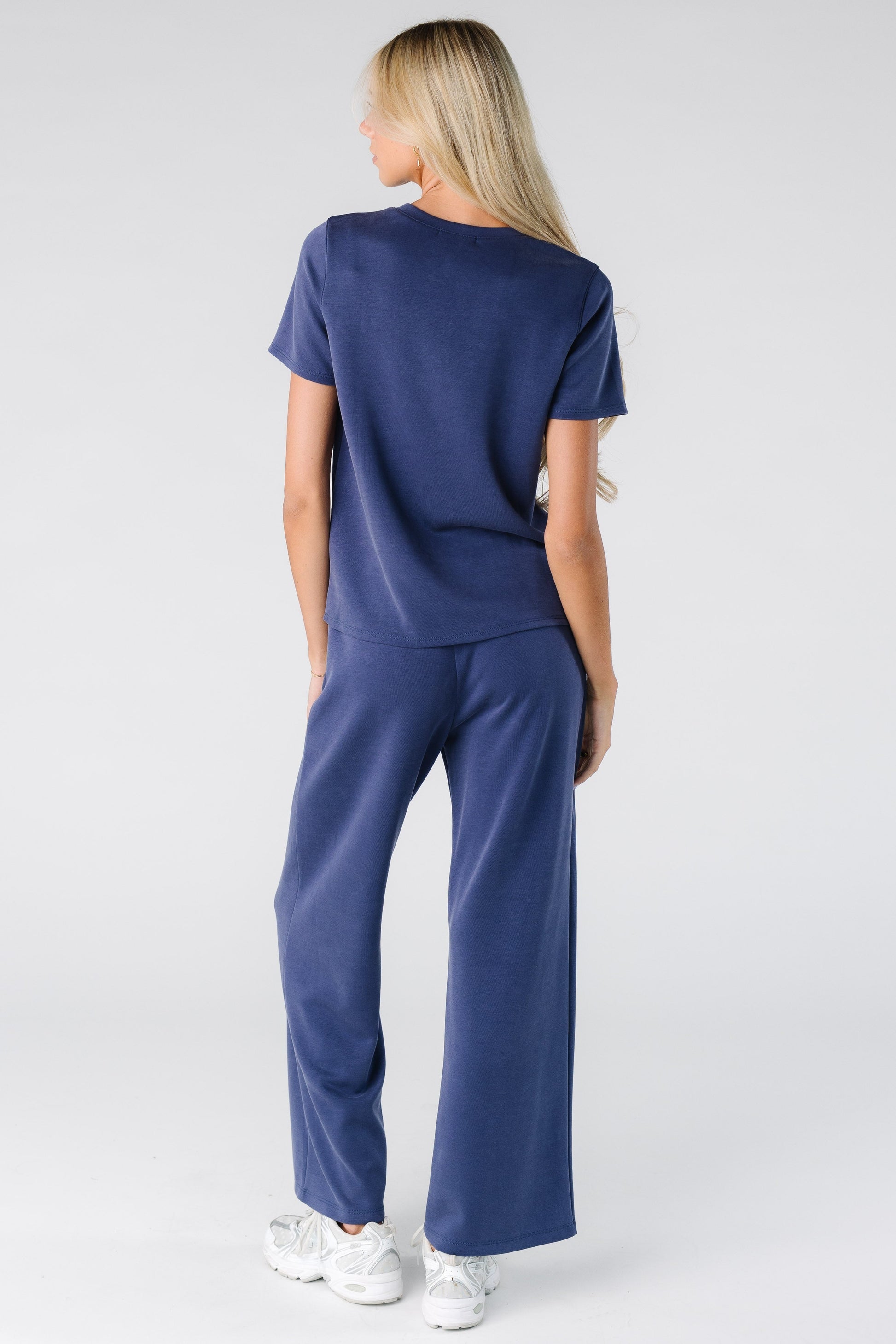 Back view of a woman wearing a blue lounge set with short sleeves and full length pant