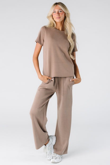 Woman wearing a modest 2 piece lounge get with short sleeves and full length pants in mocha