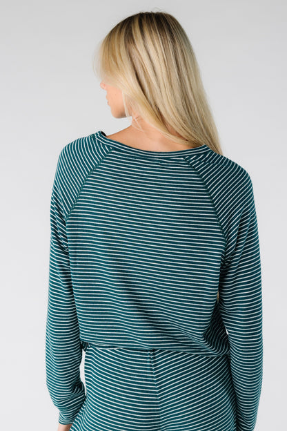 Back view of a women wearing a long sleeve soft top with round neckline
