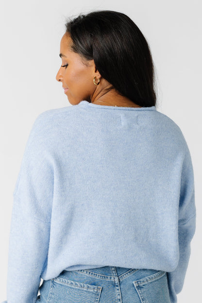 Back view of a woman wearing a light blue sweater