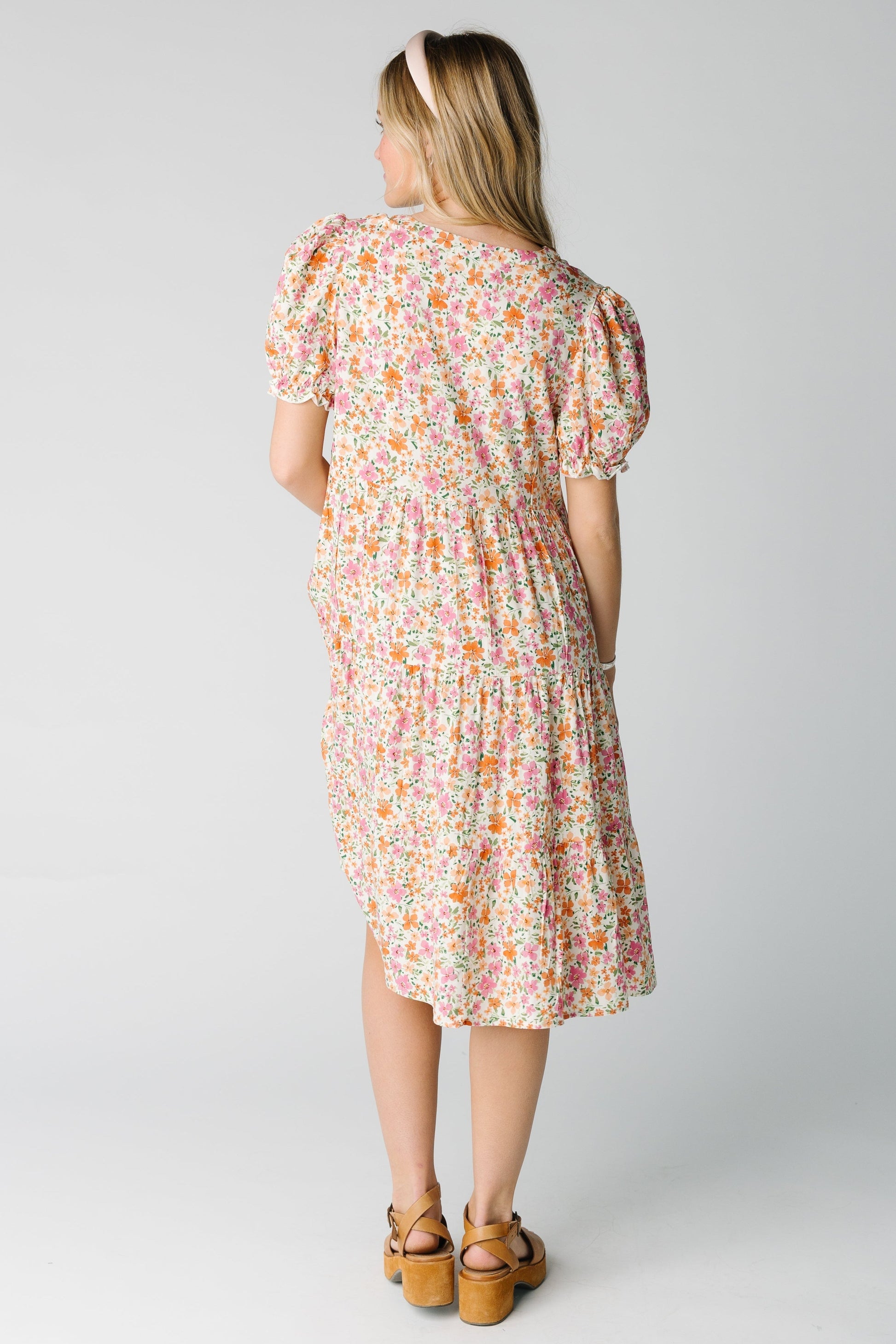 Back view of a woman wearing a pink multi floral dress 