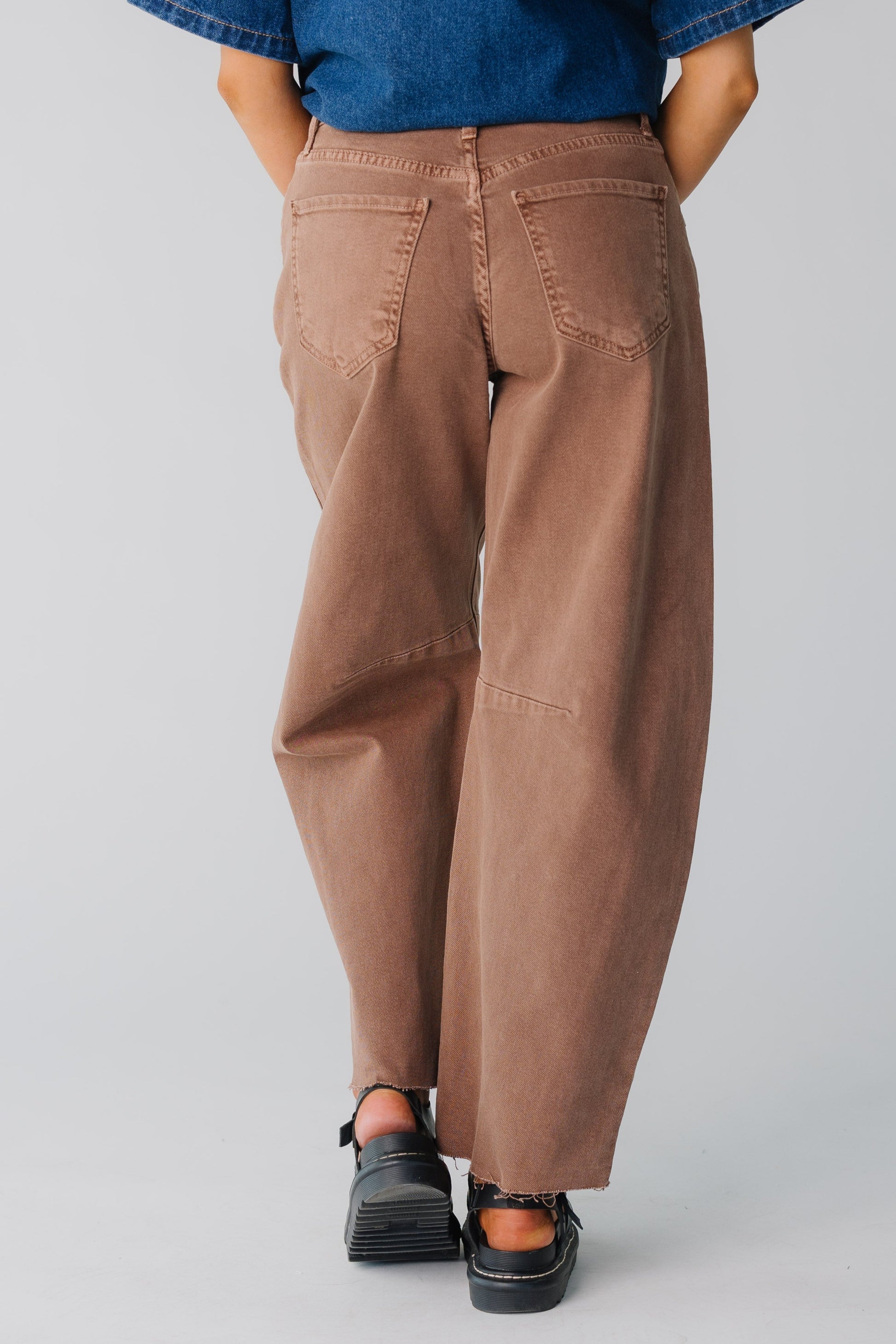 Woman wearing brown barrel cut jeans in brown