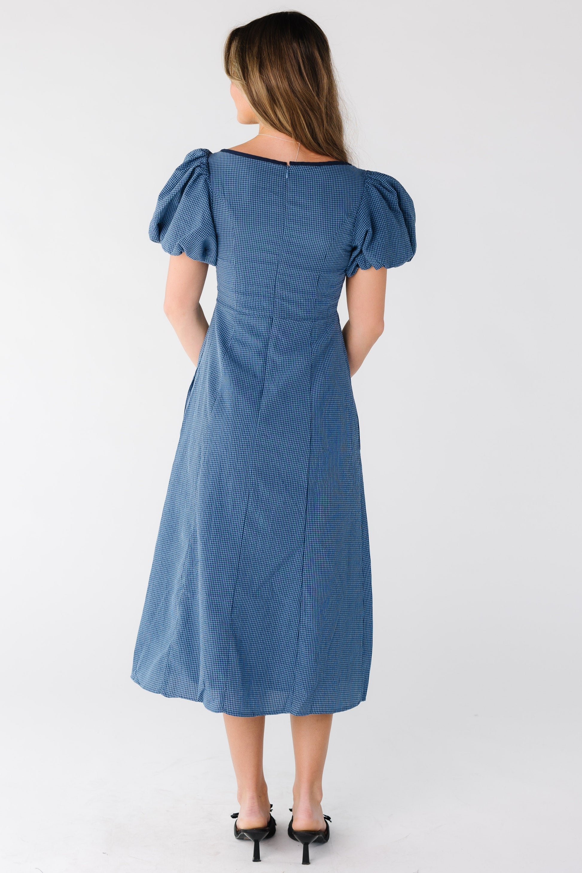 Back view of a woman wearing a blue gingham midi dress