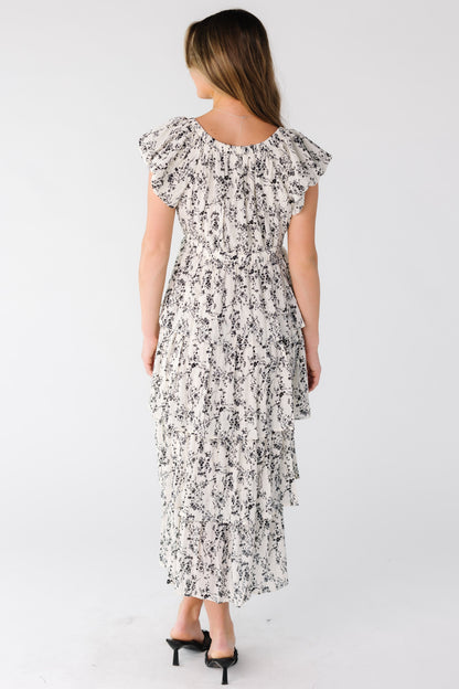 Back view of a woman wearing a white print tiered midi dress