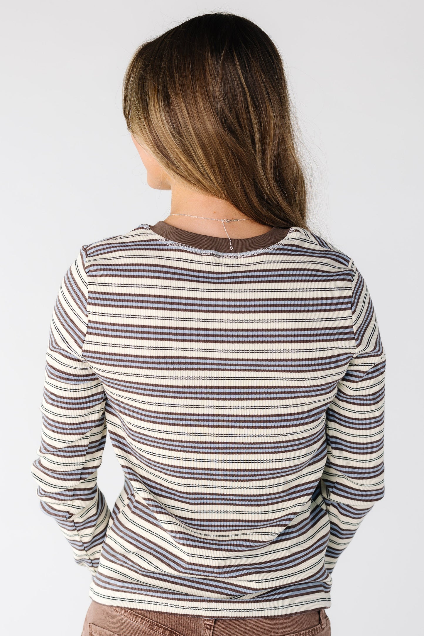 Back view of a woman wearing a multi color stripe top