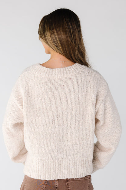Back view of a woman wearing a cream loose fitting sweater