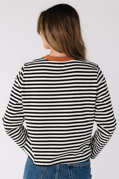 Back view of a women wearing a black and white stripe tee with long sleeves