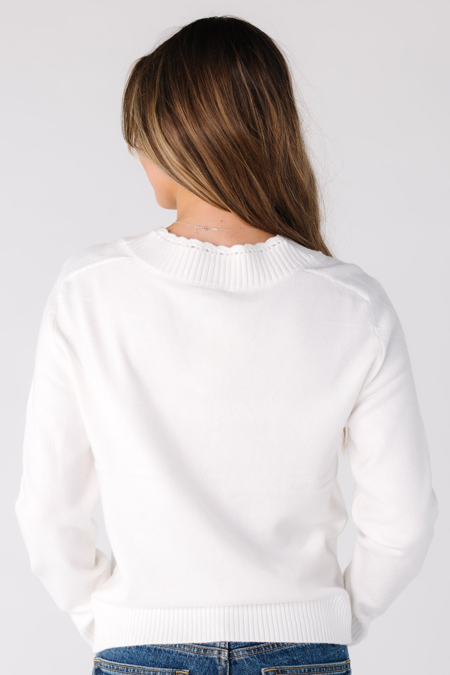 Back view of a woman wearing an off white sweater