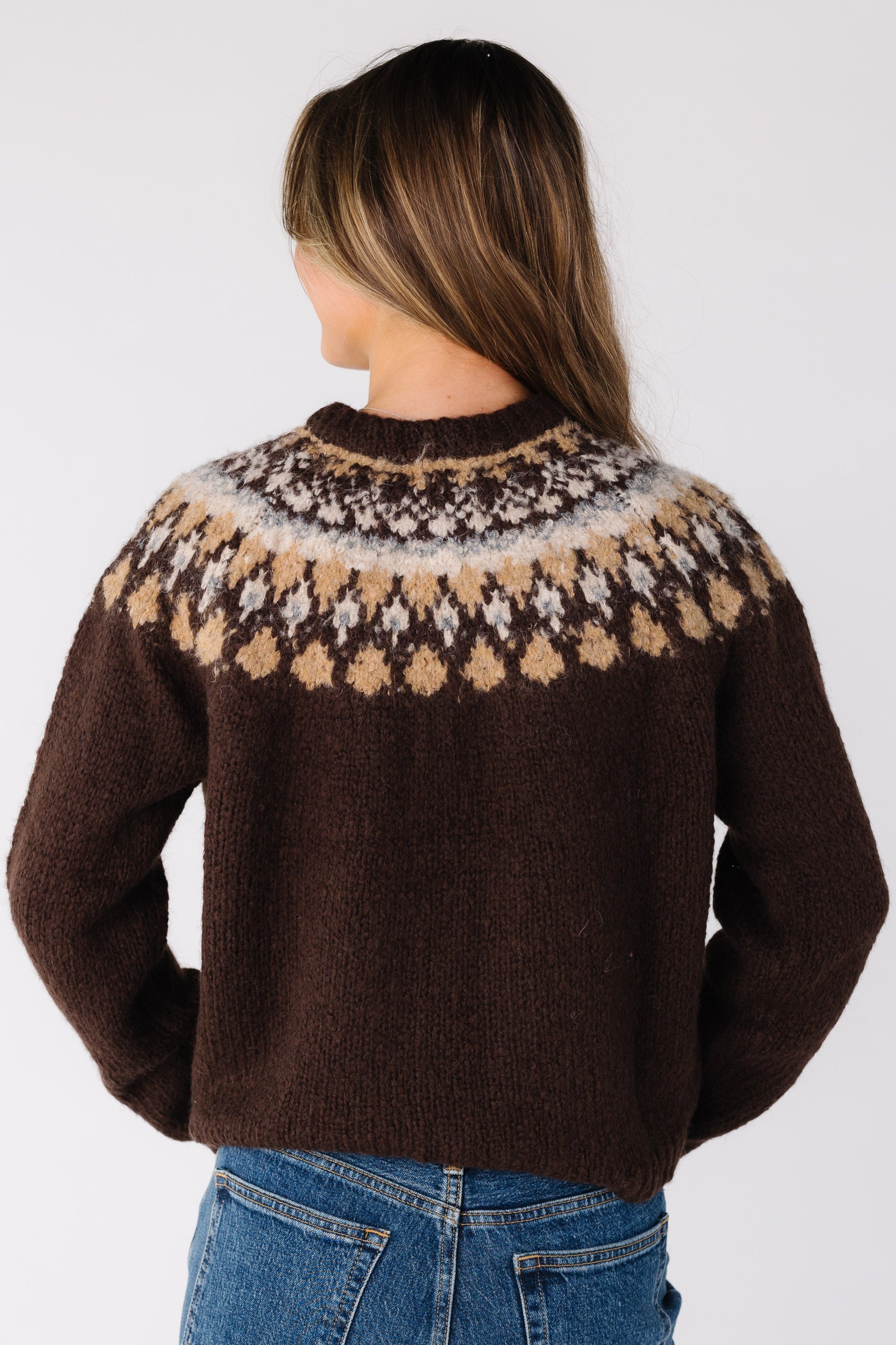 Back view of a woman wearing a brown Fair Isle cardigan