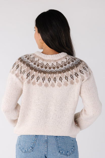Back view of a woman wearing an ivory sweater with long sleeves
