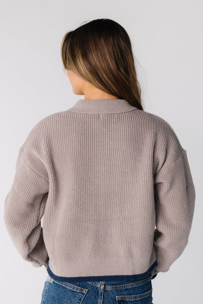 Back view of a woman wearing a taupe long sleeve cardigan