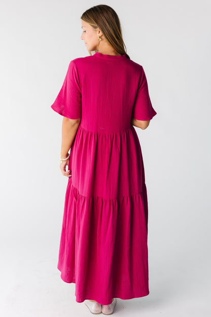 Back view of a woman wearing a  fuchsia midi maxi dress with short sleeves