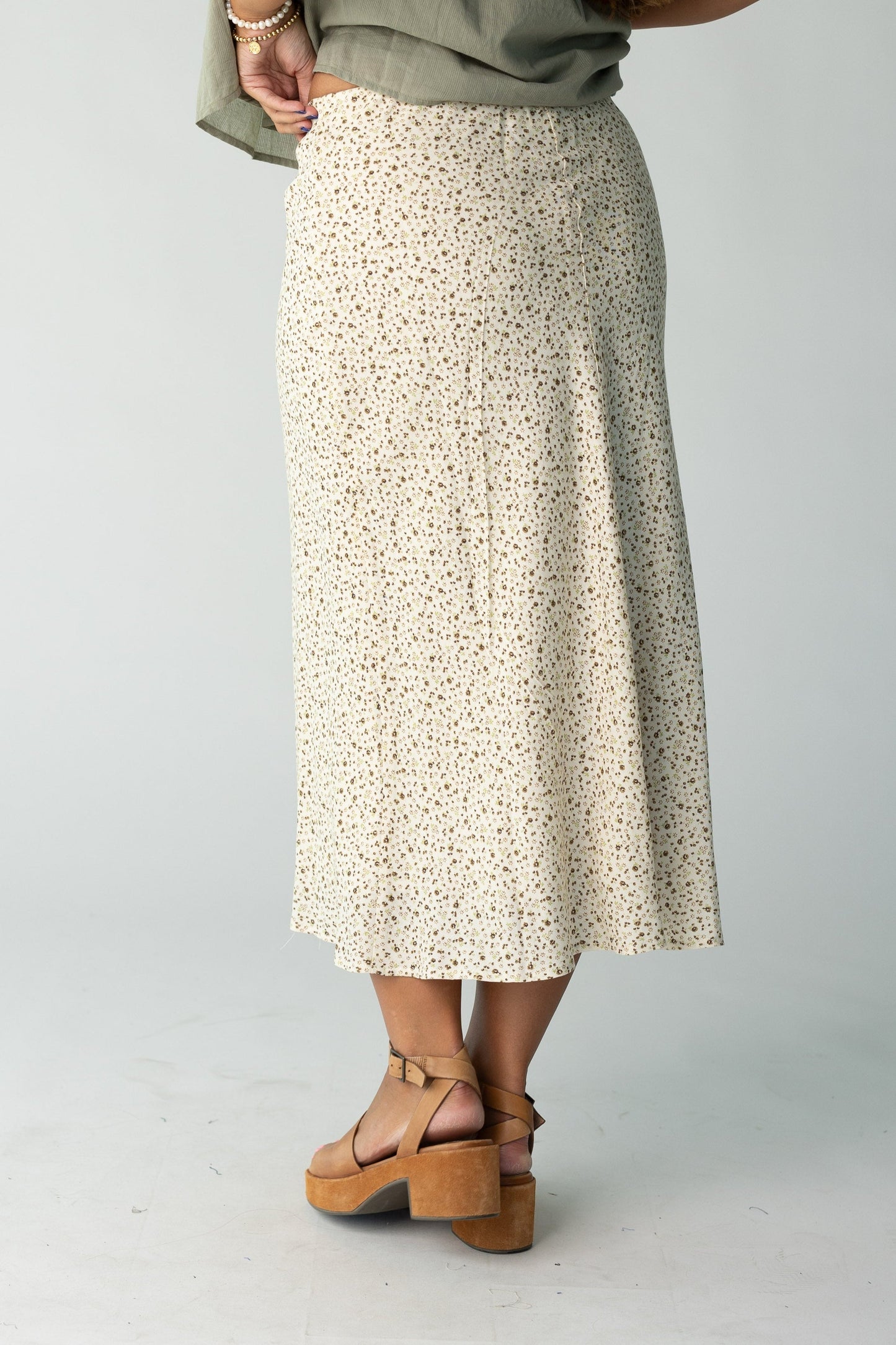 Back view of a woman wearing a cream floral print midi skirt