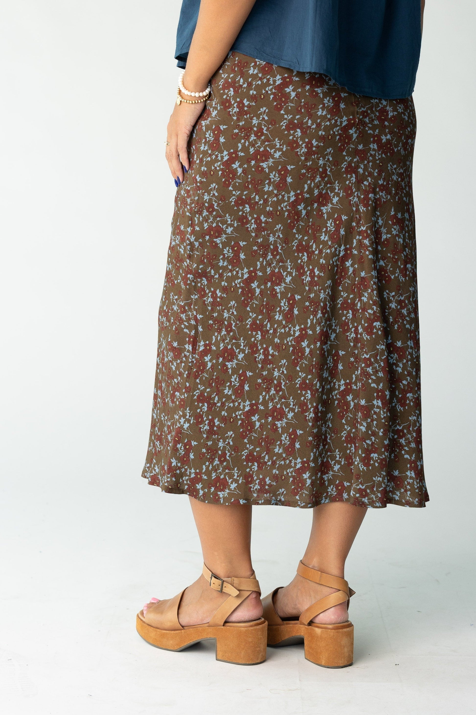 Back view of a woman wearing a brown floral print midi skirt