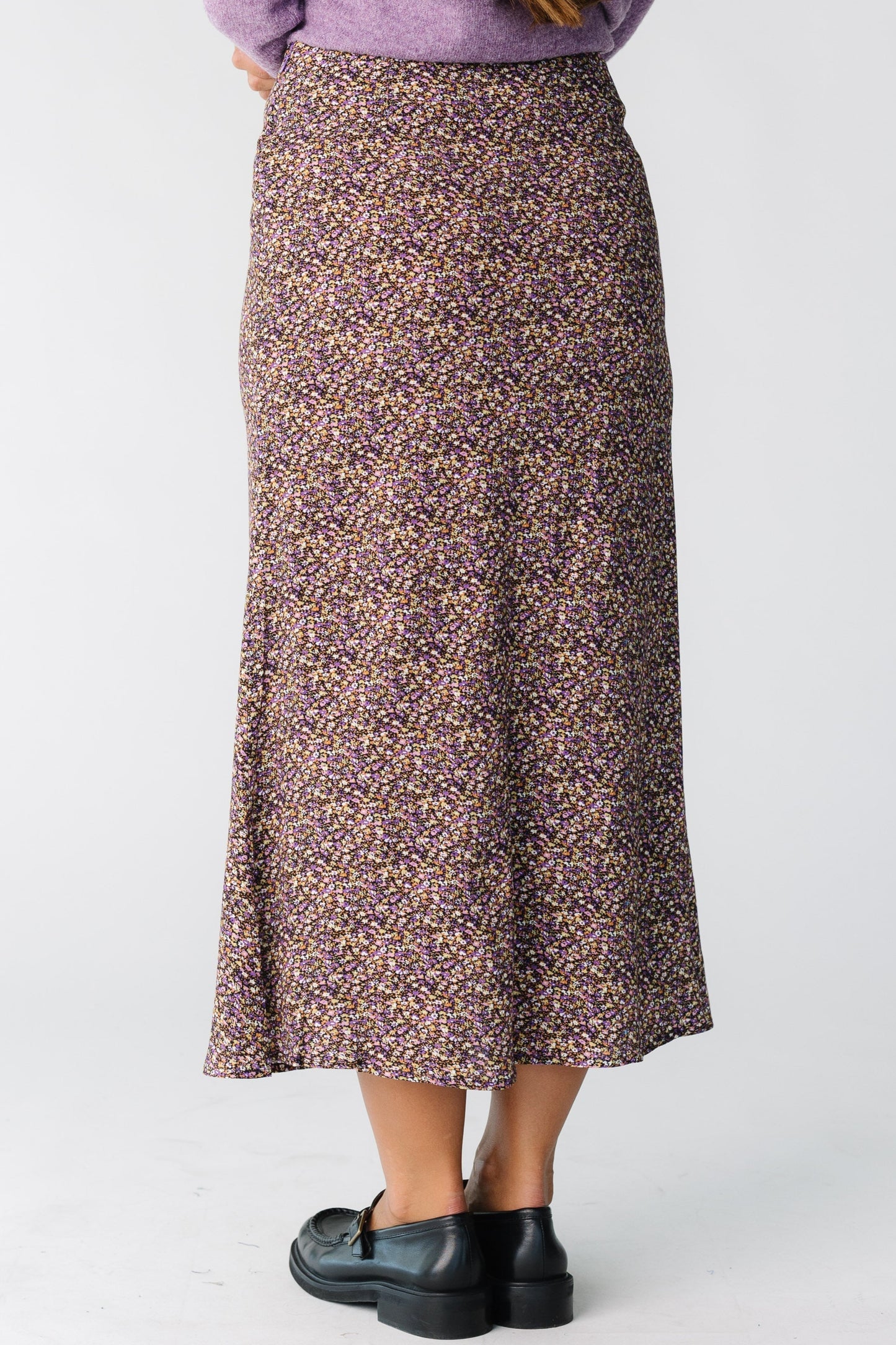 Back view of a woman wearing a floral print midi skirt