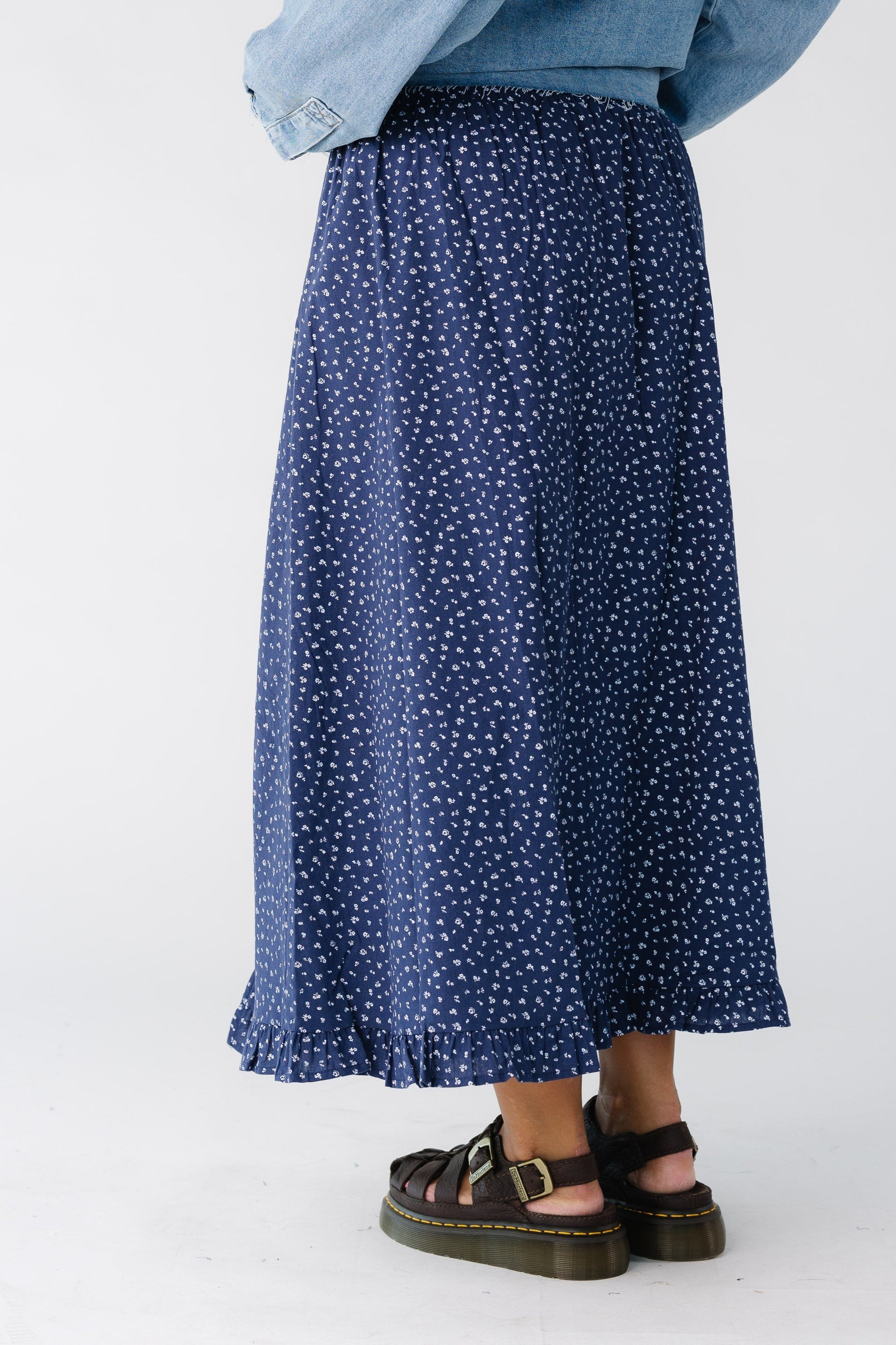 Back view of a woman wearing a navy floral midi skirt 