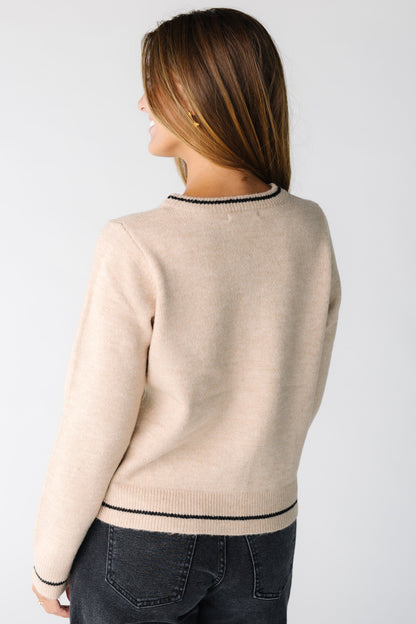 Back view of a woman wearing a taupe sweater with black stripes