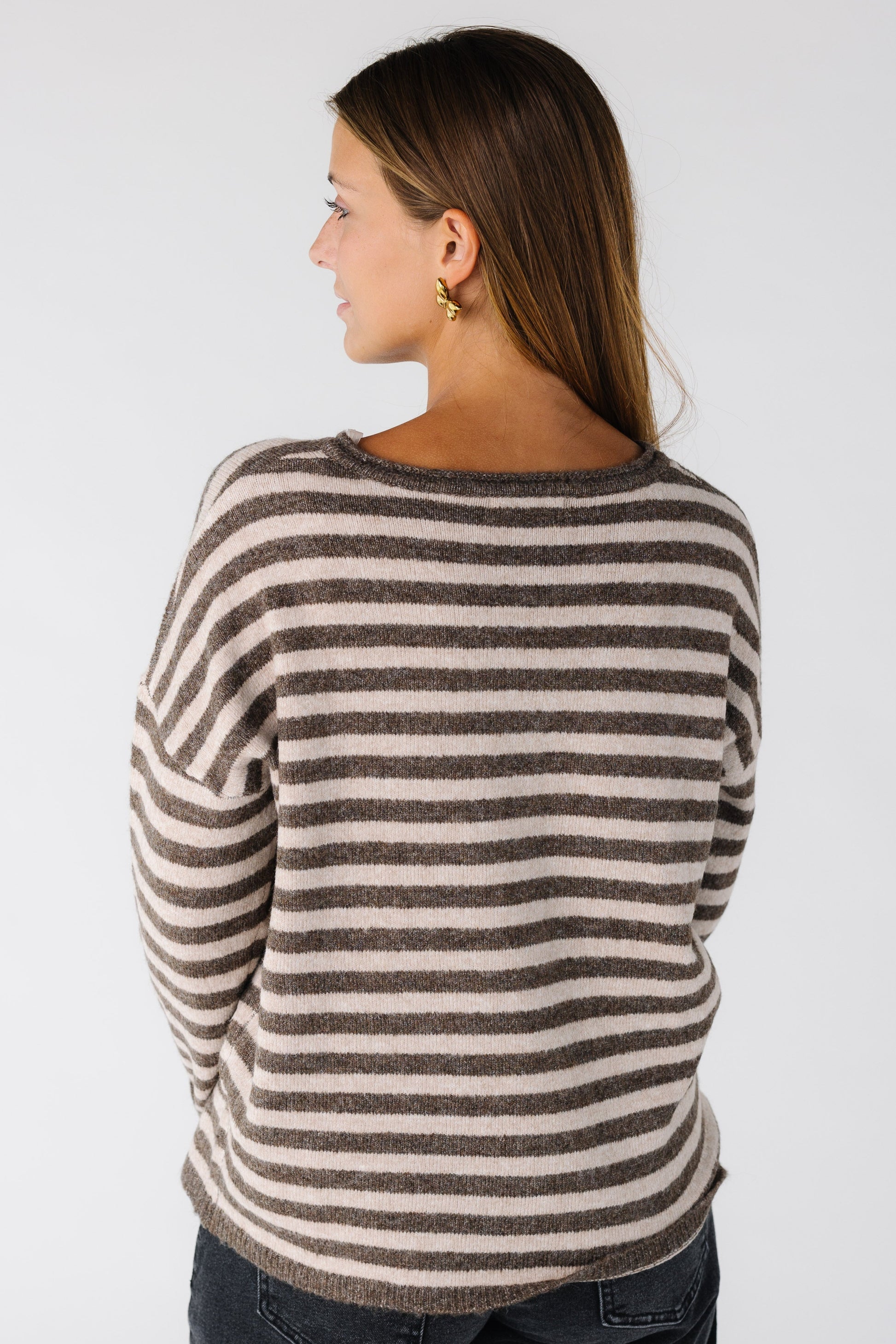Back view of a woman wearing a  mocha stripe cardigan with long sleeves