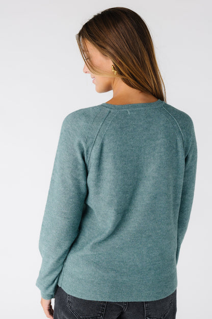 Back view of a woman wearing a  teal sweater