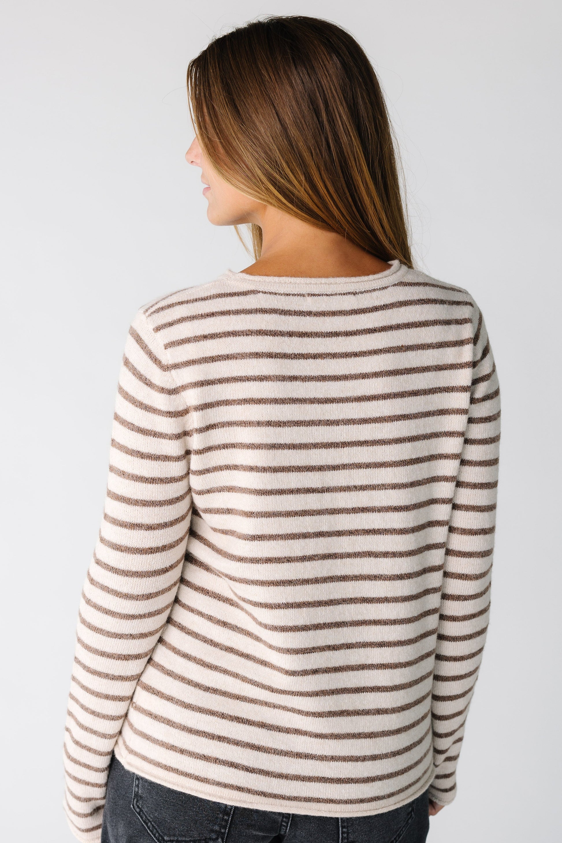Back view of a woman wearing a mocha and cream stripe sweater