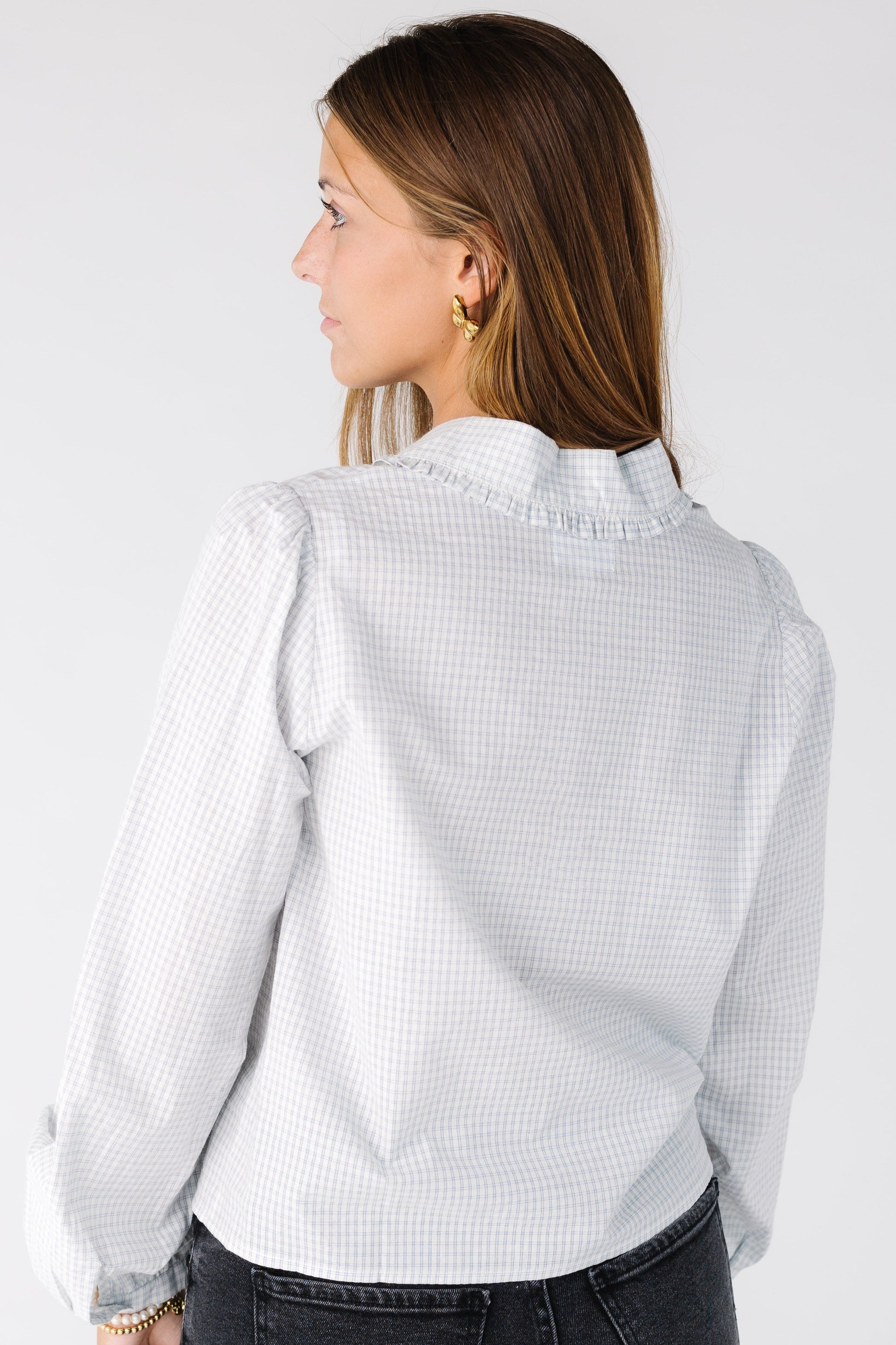 Back view of a woman wearing a blue plaid top