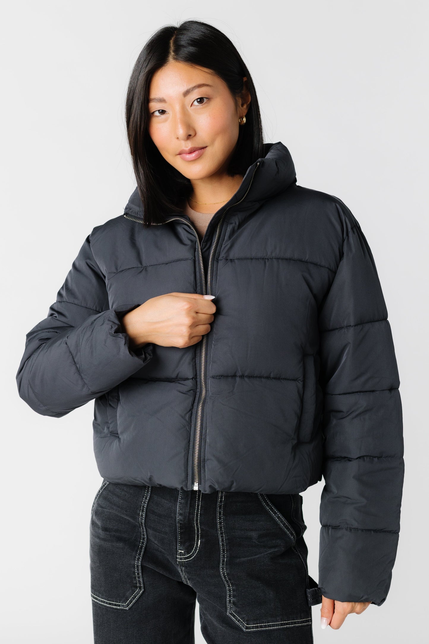 Black puffer jacket with front pockets and exposed zipper