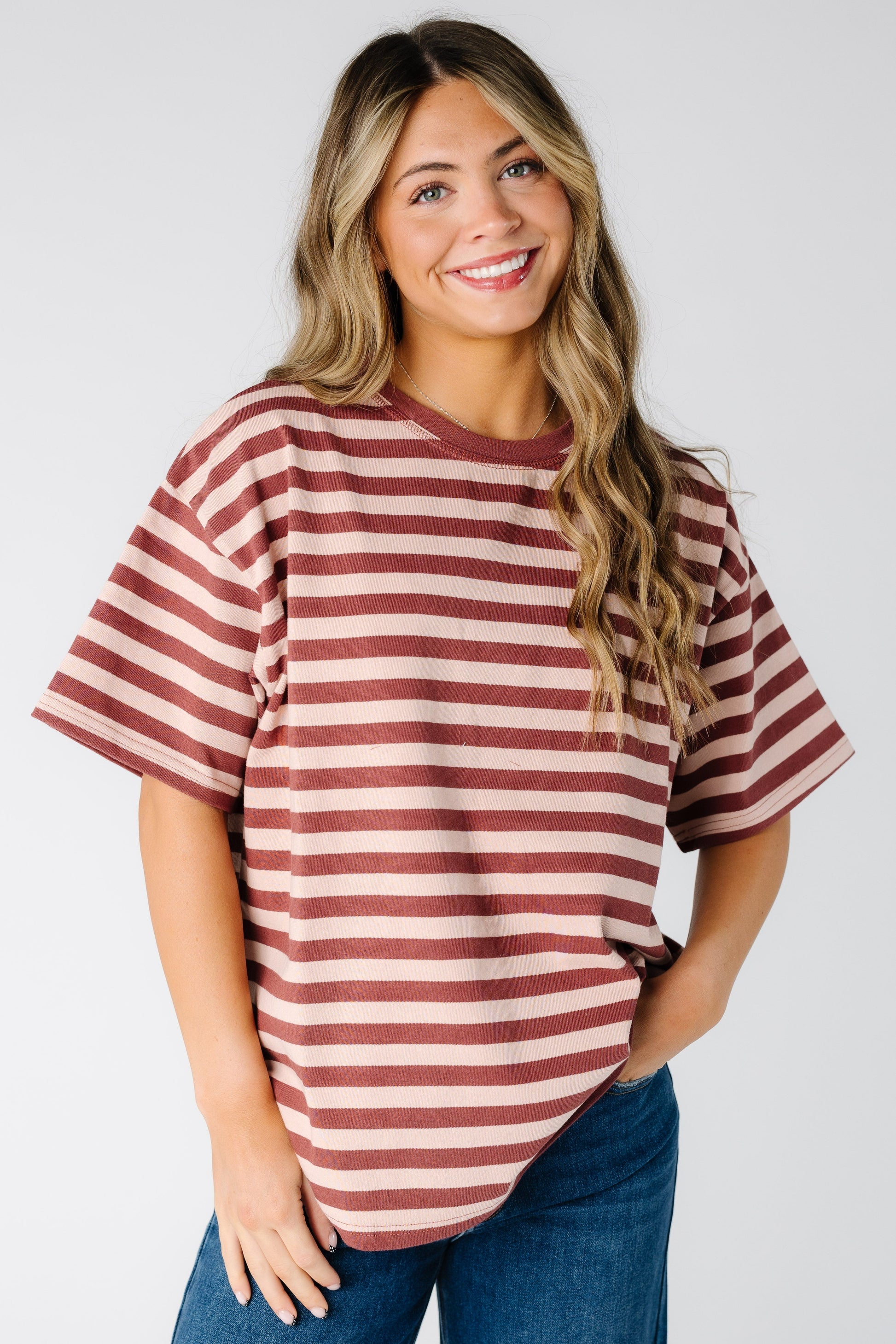 Woman wearing a modest blush stripe tee with short sleeves and crew neckline