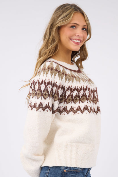 A side view of a woman wearing a cream pullover sweater with a nordic pattern in beige & brown.