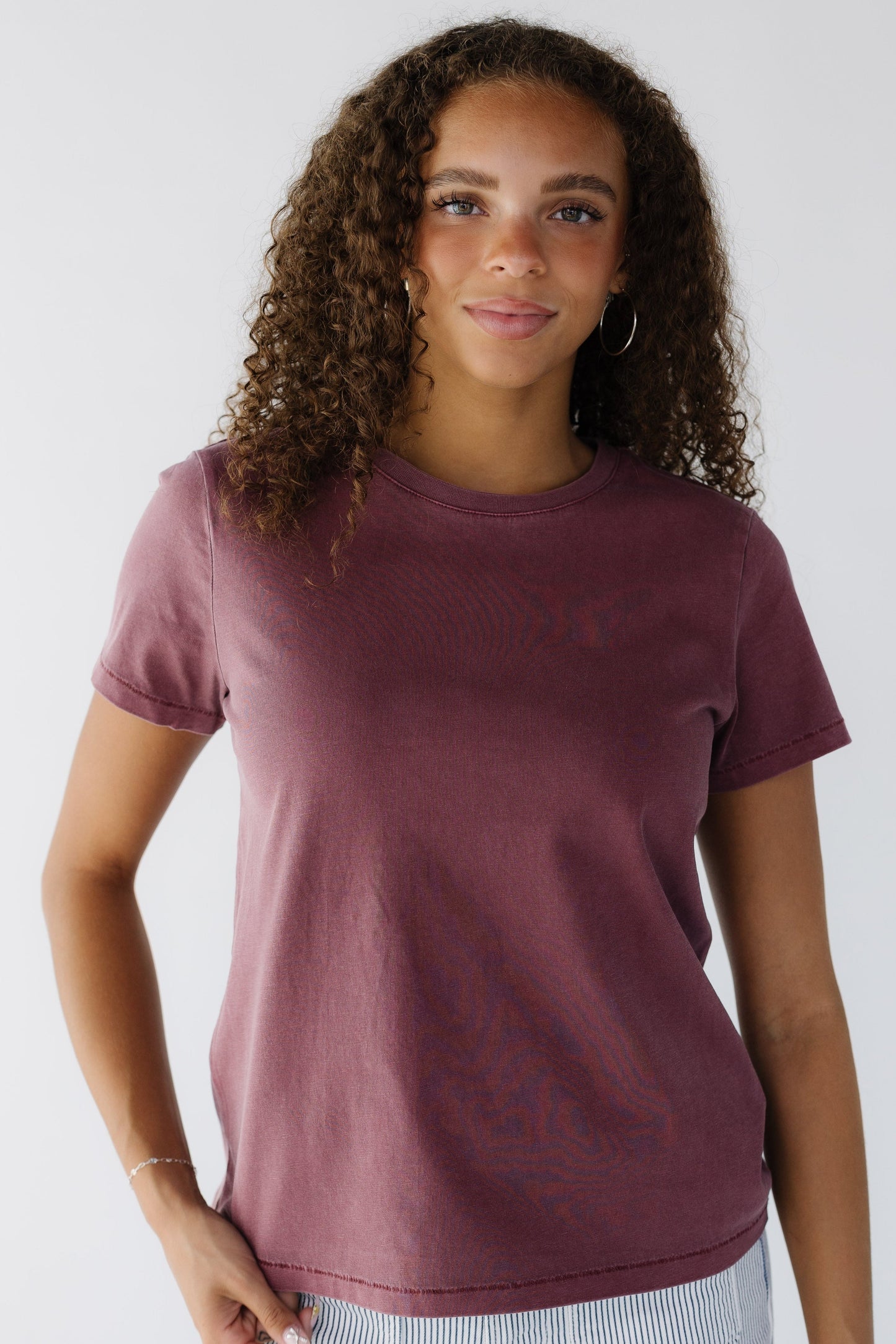 Teenage girl wearing a wine color short sleeve tee with a round neckline.