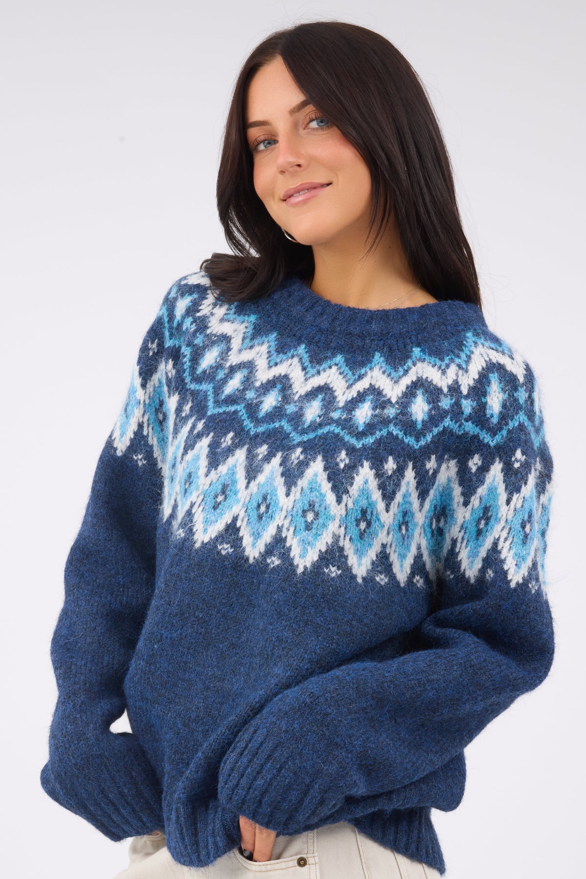 A young woman wearing a modest navy nordic sweater in blue & white with a crew neckine and long sleeves.