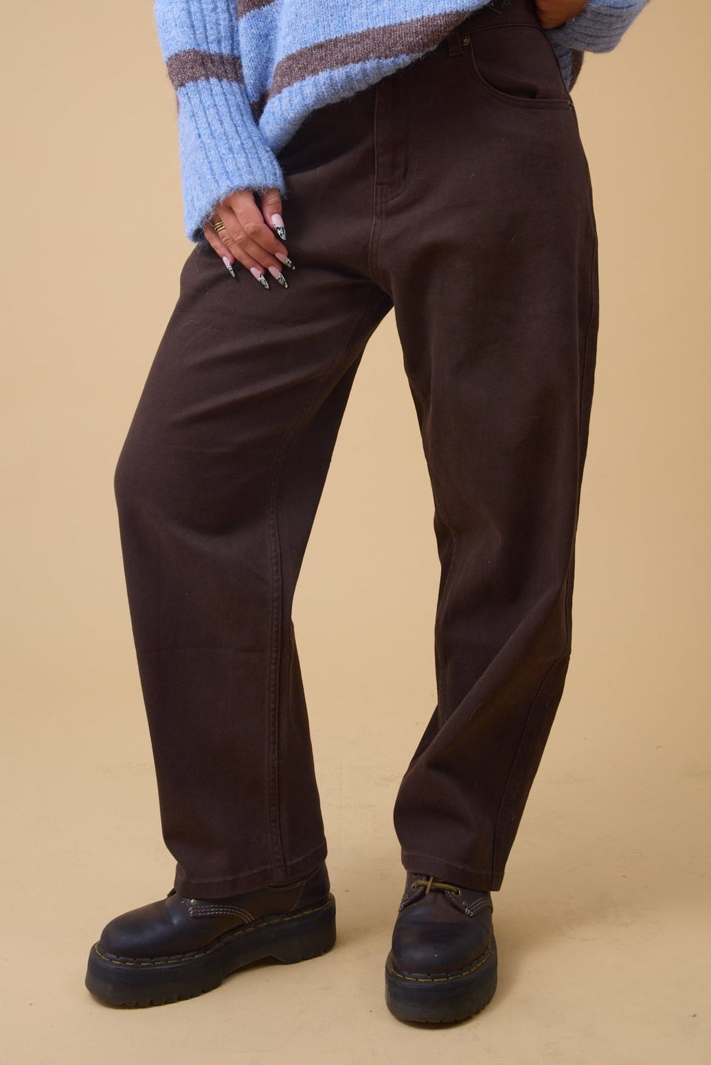 Young woman wearing a modest wide leg pant in brown.