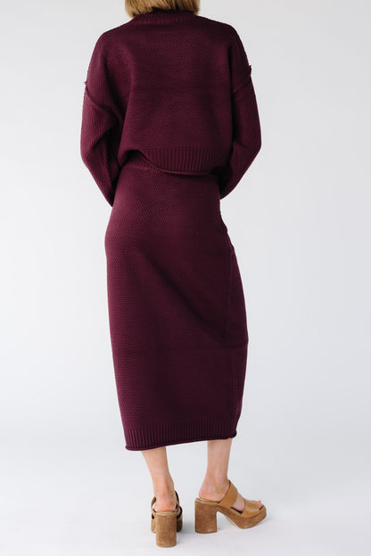 Close view of a woman wearing a burgundy closer fitting a midi length pencil skirt