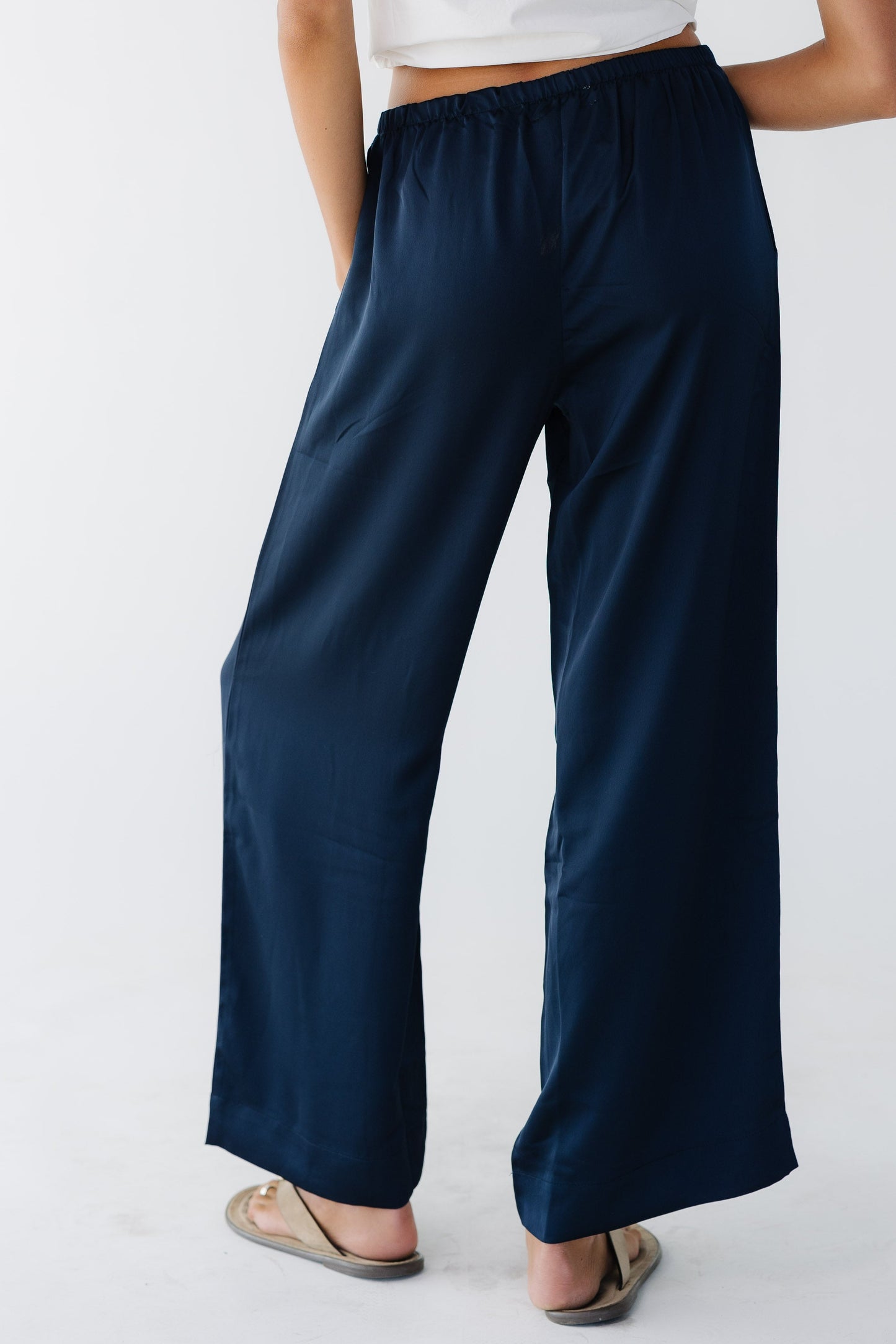 Back view of a woman wearing a navy wide leg pant with an elastic waistband.
